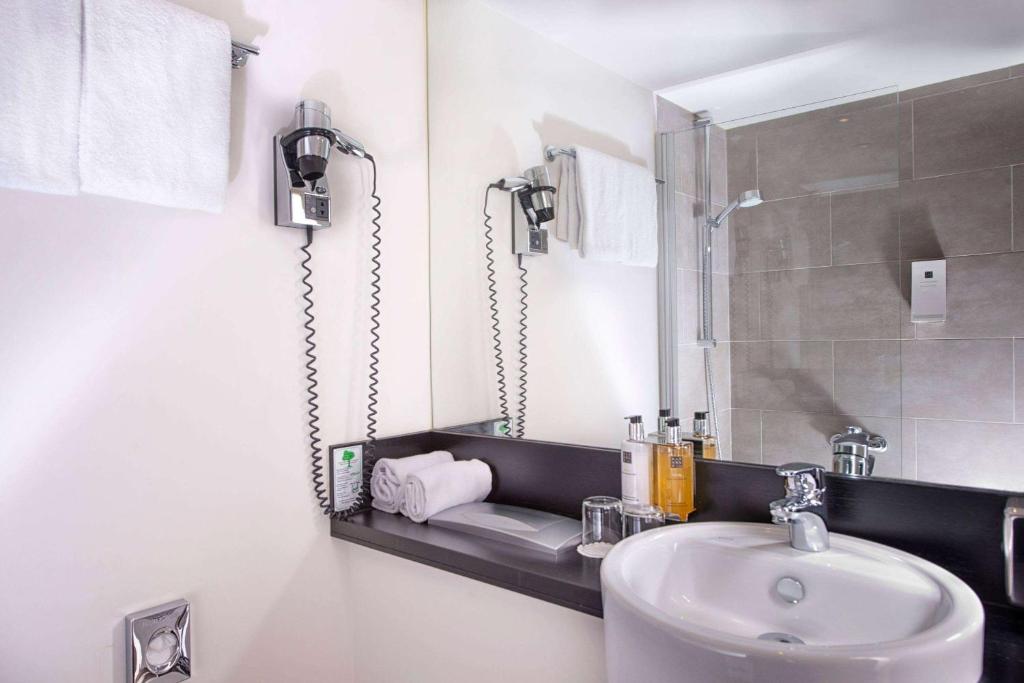 a bathroom with a sink and a mirror at Wyndham Stuttgart Airport Messe in Stuttgart