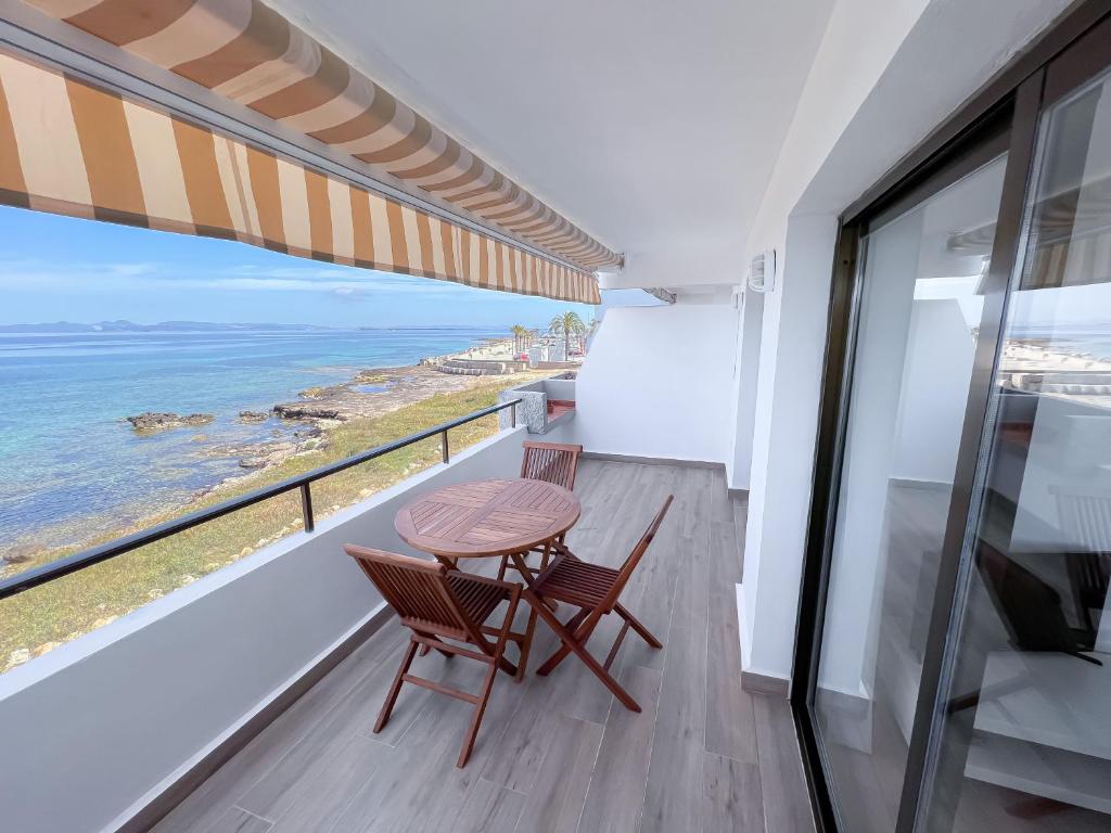 ein Balkon mit Tisch und Stühlen und dem Meer in der Unterkunft Turquesa & Ambar Apartments Formentera in La Savina