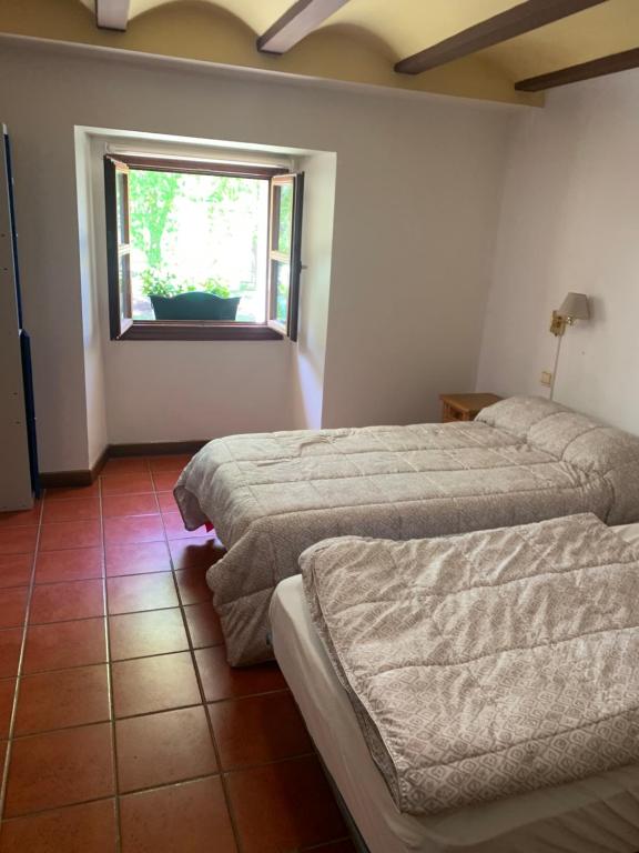 a room with two beds and a window at Albergue de Nuestra Señora Carrasquedo in Grañón
