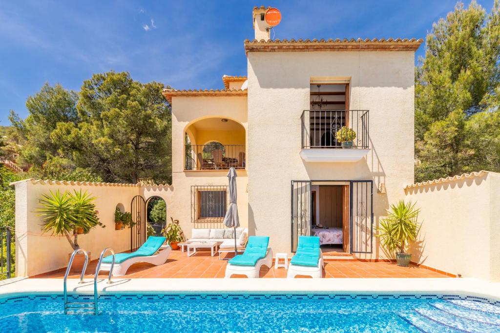 a villa with a swimming pool in front of a house at Holiday Villa Near Denia in Adsubia