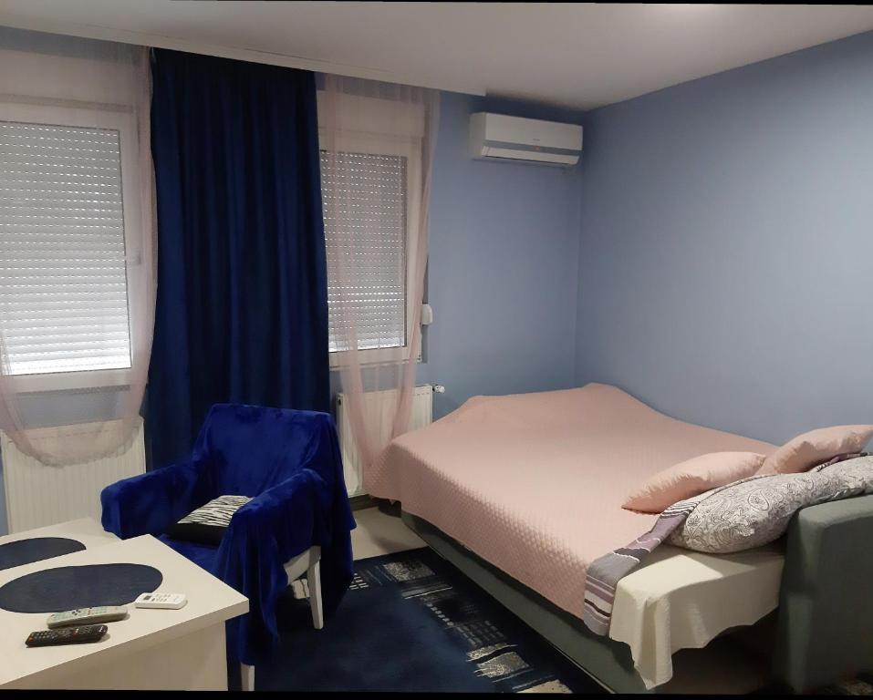 um quarto com 2 camas, uma mesa e uma cadeira em MIMOZA 1 em Jagodina