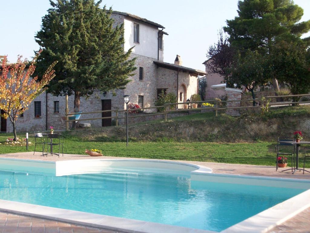 a large swimming pool in front of a house at Girasole - Agriturismo Fogliani in Giano dellʼUmbria