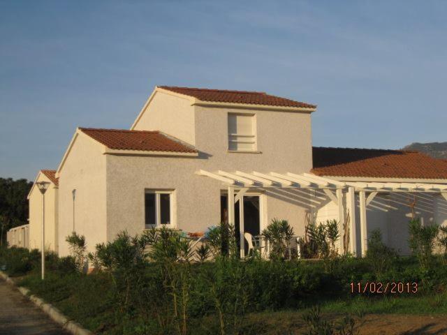 una grande casa bianca con tetto di VILLA T3 bord de mer - vue mer à 500 m de la plage- piscine chauffée A CASETTA DI A SPIAGGIA a Cervione