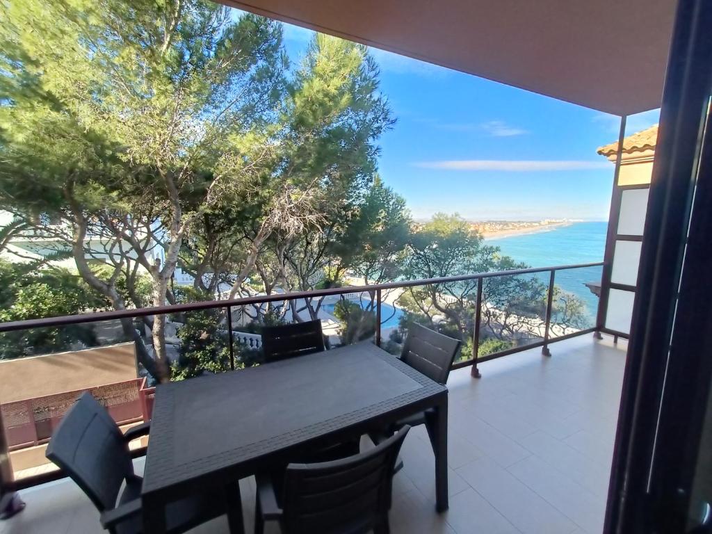 a table and chairs on a balcony with a view of the ocean at Aparthotel El Faro in Cullera