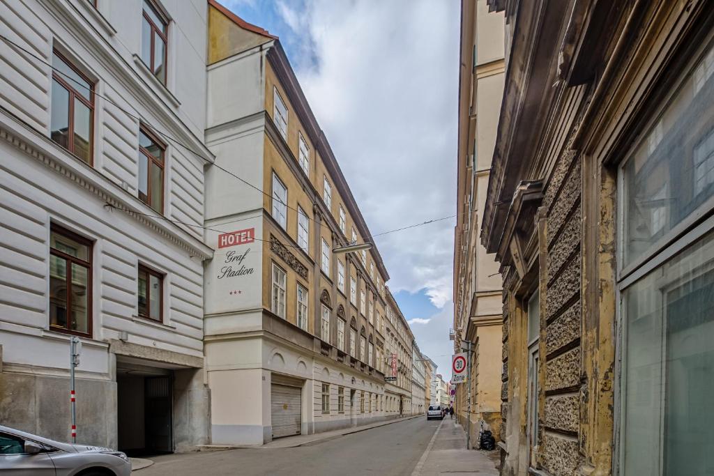 an empty street in a city with tall buildings at Hotel Graf Stadion in Vienna