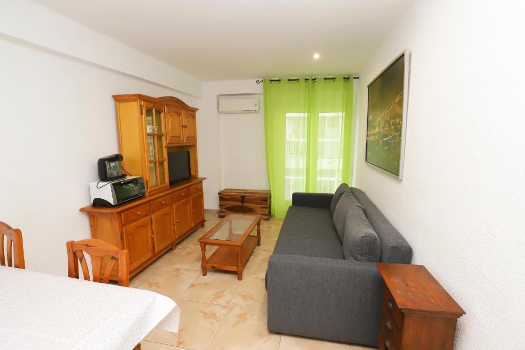 sala de estar con sofá y TV en DIFFERENTFLATS Acantilados, en Salou