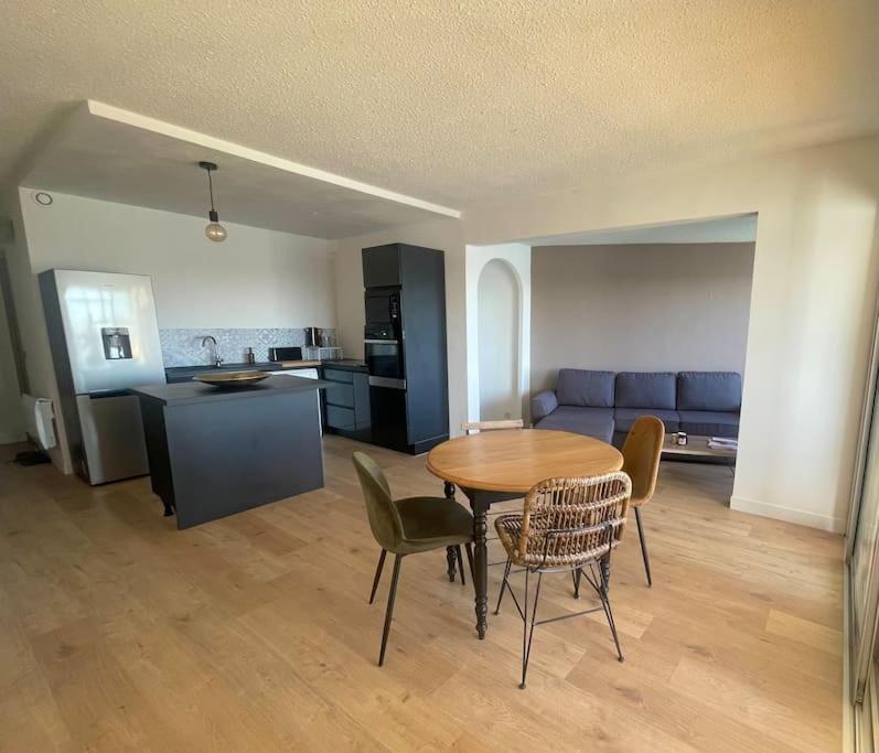 un salon avec une table et des chaises et une cuisine dans l'établissement Appartement vue sur le port, à Gruissan