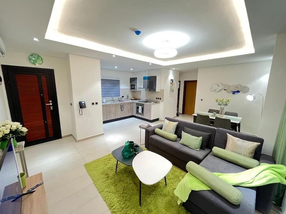 sala de estar amplia con sofá y cocina en The Green Escape - Cantonments, en Accra