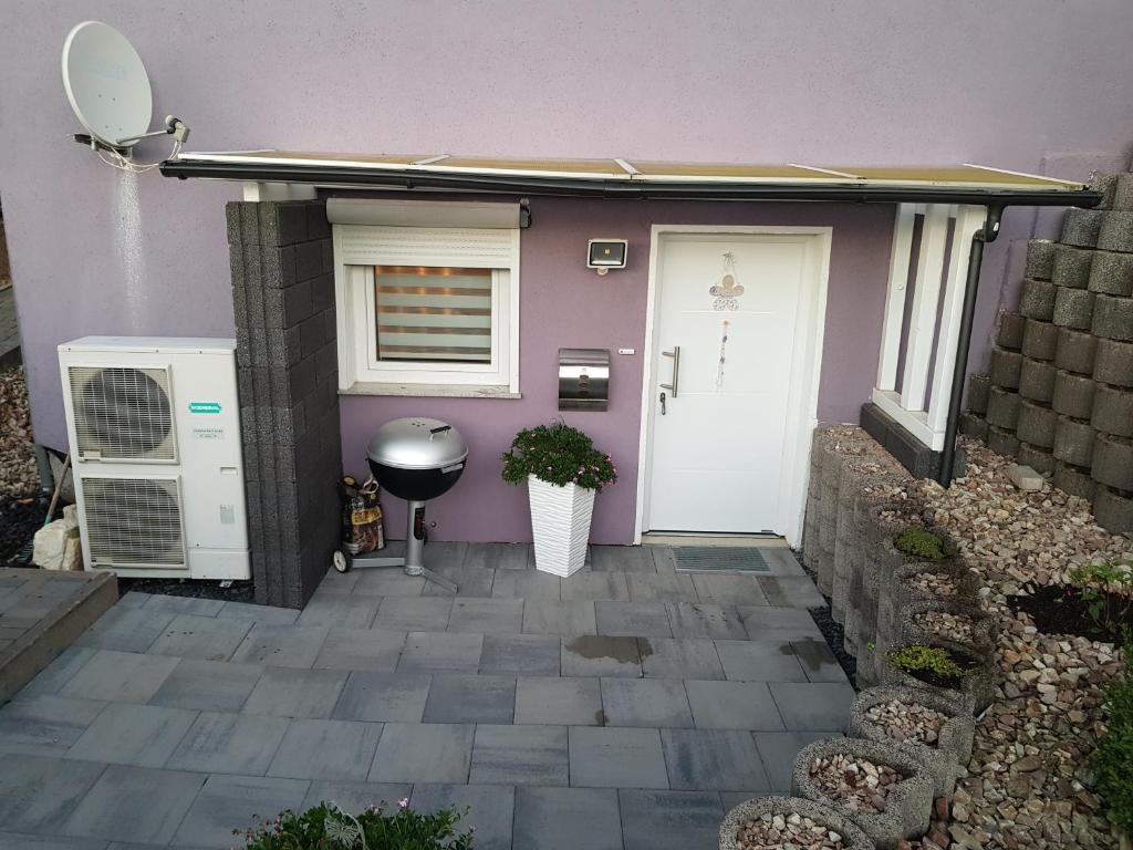 a purple house with a white door and a window at Lila Pause in Ellweiler