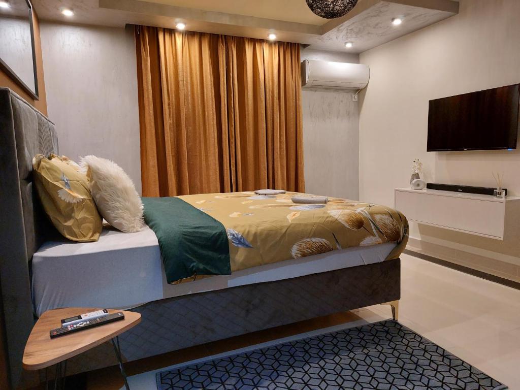 1 dormitorio con 1 cama, TV y mesa en Elite-stan na dan, en Berane