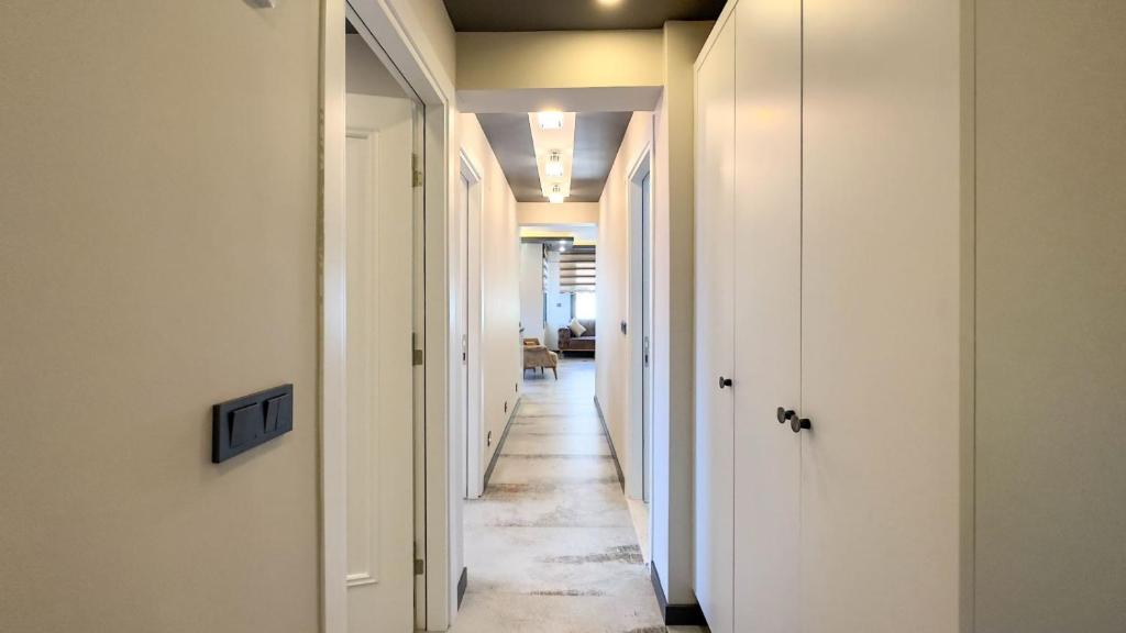 a hallway with white walls and a long hallway with white doors at PALM BEACH APARTMENT in Kuşadası