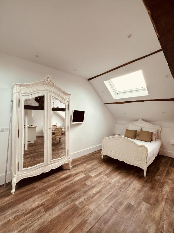 a bedroom with a white bed and a mirror at Studio 3 du SPA Célinie in Warcq