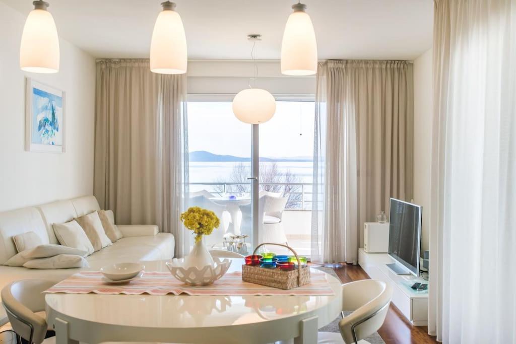 uma sala de estar com um sofá branco e uma mesa em Apartment Sunset, Zadar - Kožino em Kožino