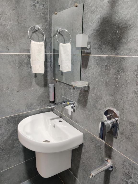 a bathroom with a white sink and a mirror at Hotel Tamanna - 50 Meter from Golden Temple in Amritsar