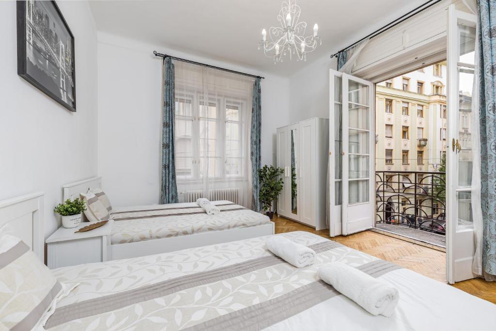 a bedroom with two beds and a balcony at Real Apartments Wesselényi II. in Budapest