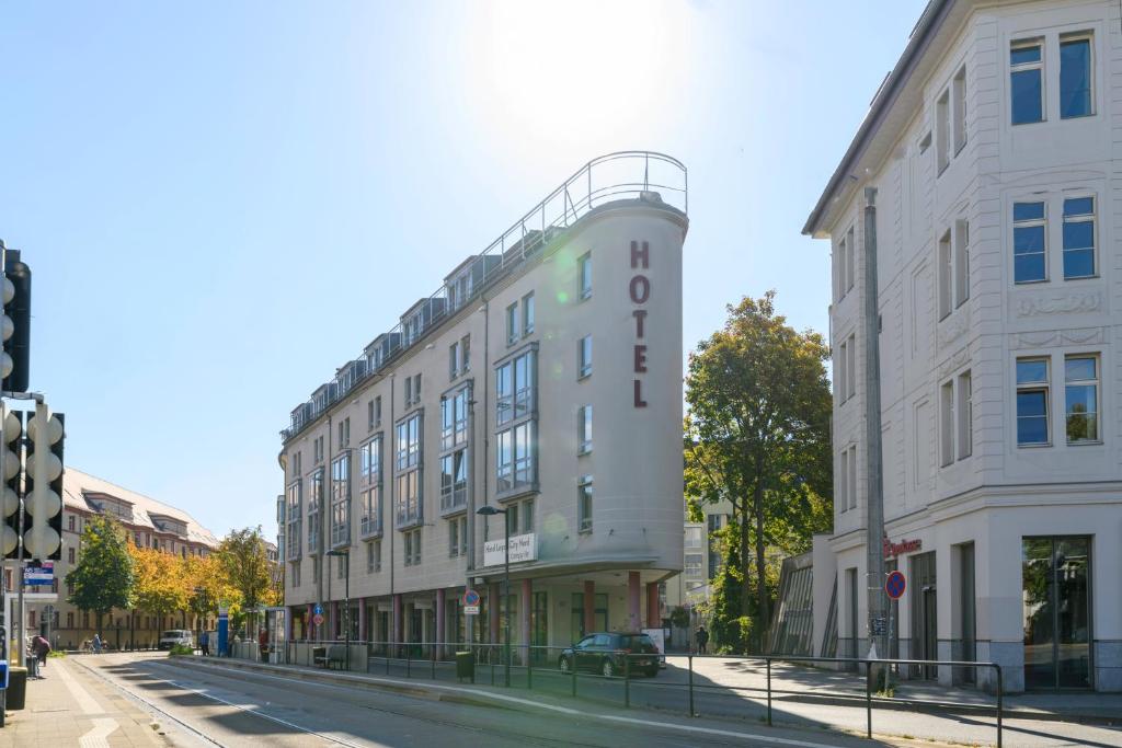 un grand bâtiment blanc dans une rue de la ville dans l'établissement Hotel Leipzig City Nord by Campanile, à Leipzig