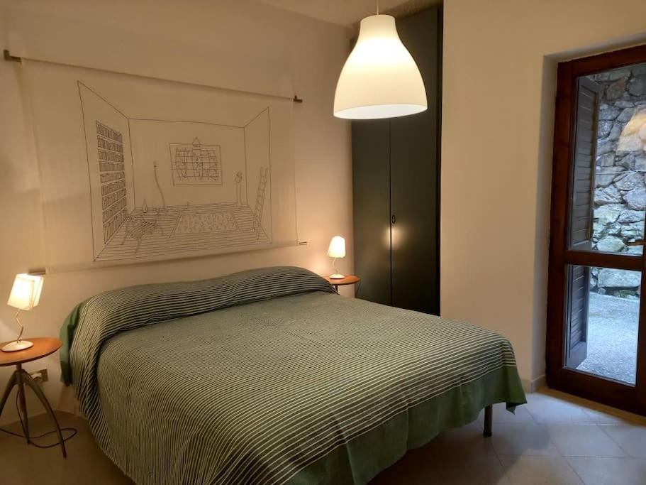 una camera con un letto e due tavoli e una lampada di Villetta Elaion a Scario