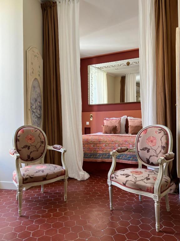 una camera da letto con un letto con due sedie e uno specchio di Studio terracotta a La Ciotat