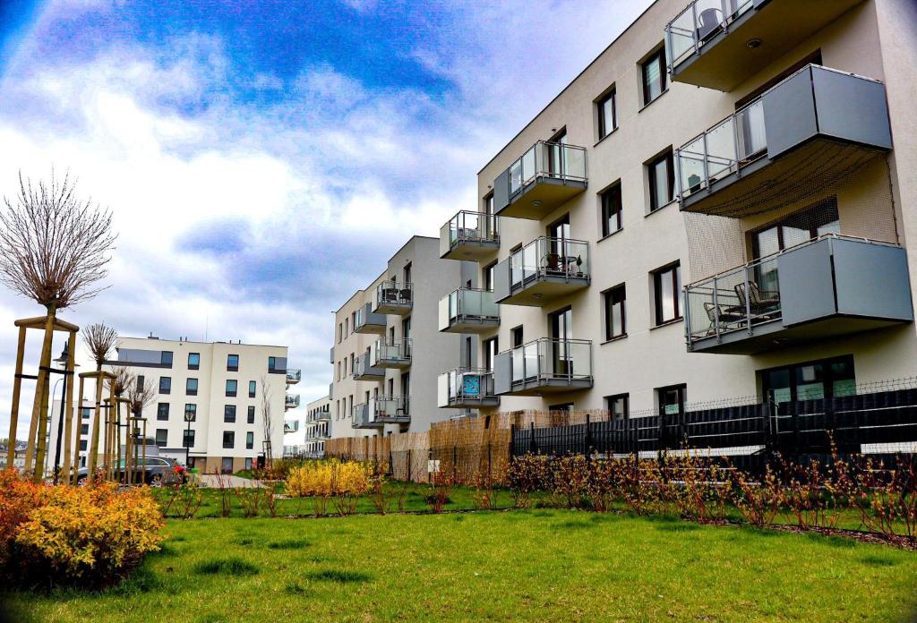 um grande edifício branco com varandas e um quintal em Lavender Hill Apartment em Gdansk