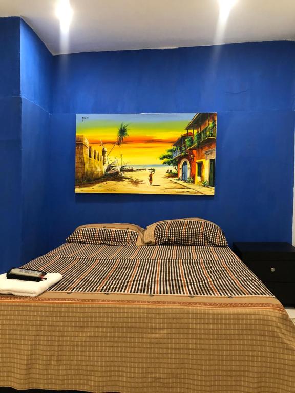 カルタヘナ・デ・インディアスにあるMartinica Hostelの青いベッドルーム(壁に絵画が描かれたベッド付)