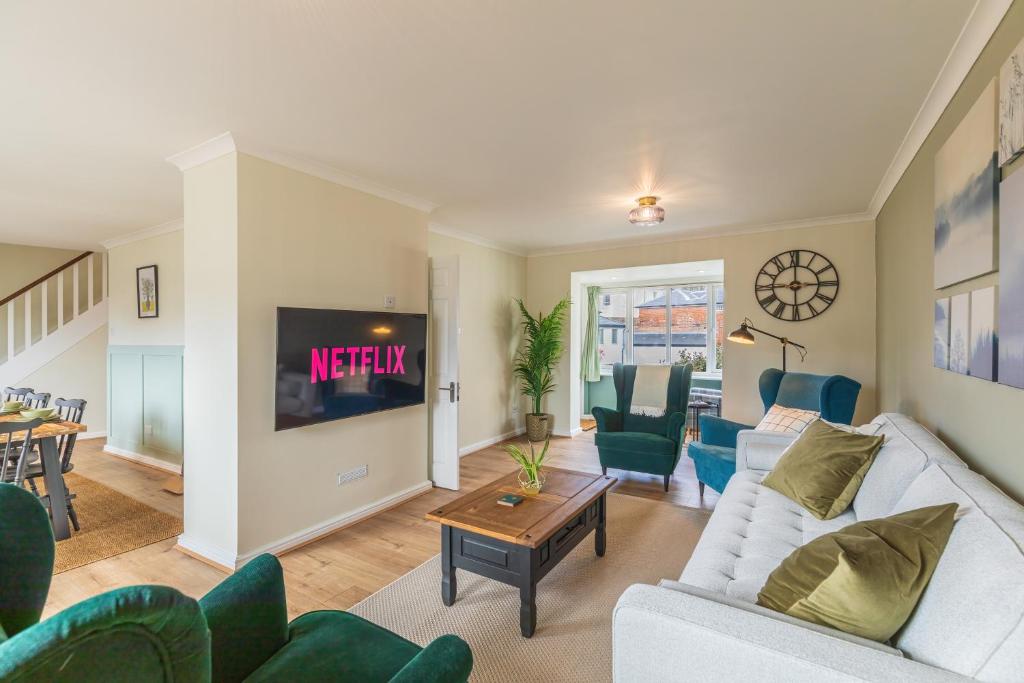 ein Wohnzimmer mit einem Sofa und einem TV in der Unterkunft 4 Bed City House with Private Garden and Parking in Winchester