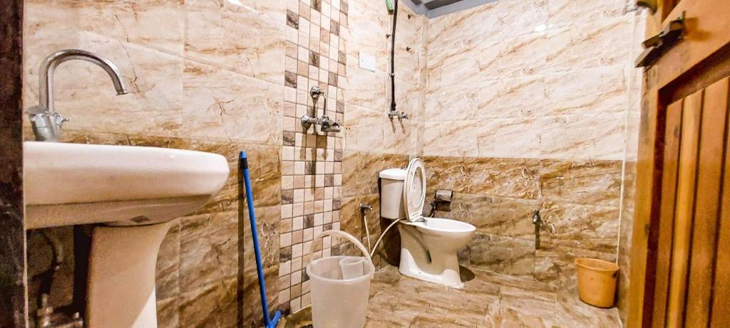 un bagno con lavandino e WC di La Vaca India Manali a Manāli