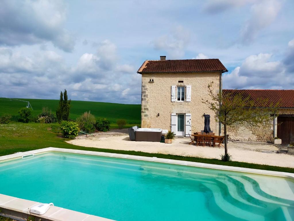 una casa y una piscina frente a un edificio en Gîte Chez Cheynaud en Celles