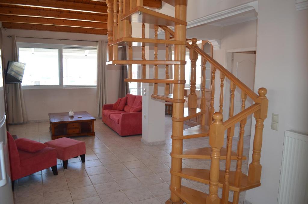 a wooden spiral staircase in a living room at Anastasia Apartment in Zakynthos