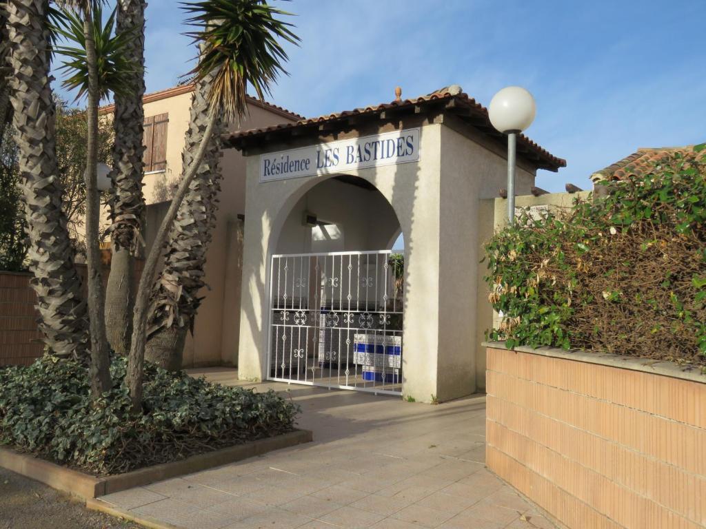 a gate to a building with palm trees at Maison "Havre de Paix" in Vias