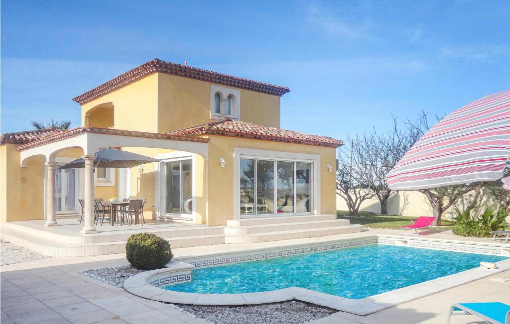 a villa with a swimming pool in front of a house at Stunning Home In Marseillan With 3 Bedrooms, Wifi And Outdoor Swimming Pool in Marseillan