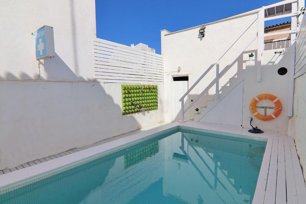 ein Pool neben einem weißen Gebäude mit einer Treppe in der Unterkunft Casa Jaume II 262 By Mallorca Charme in Muro