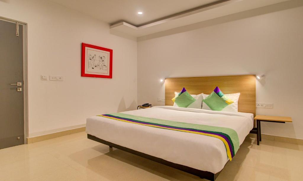 a bedroom with a large bed in a room at Treebo Trend De Alphabet Kondapur in Hyderabad