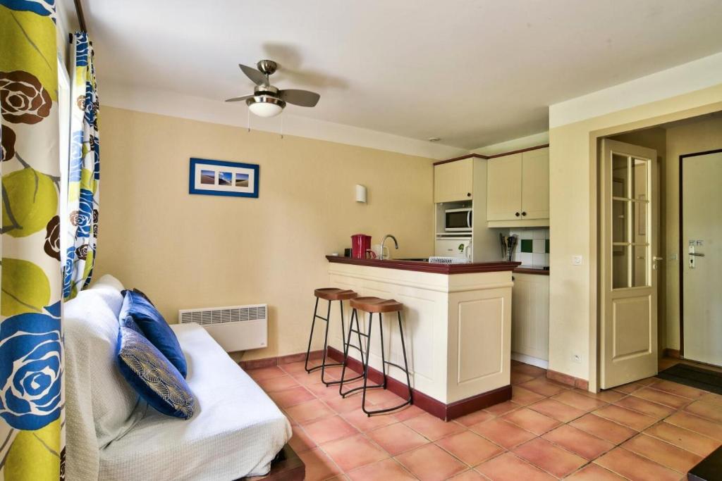 un salon avec un canapé et une cuisine dans l'établissement Les Maisons du Domaine du Golf de Pinsolle - maeva Home - Maison 3 pièces 6 personnes - Sélection MAE-0324, à Soustons