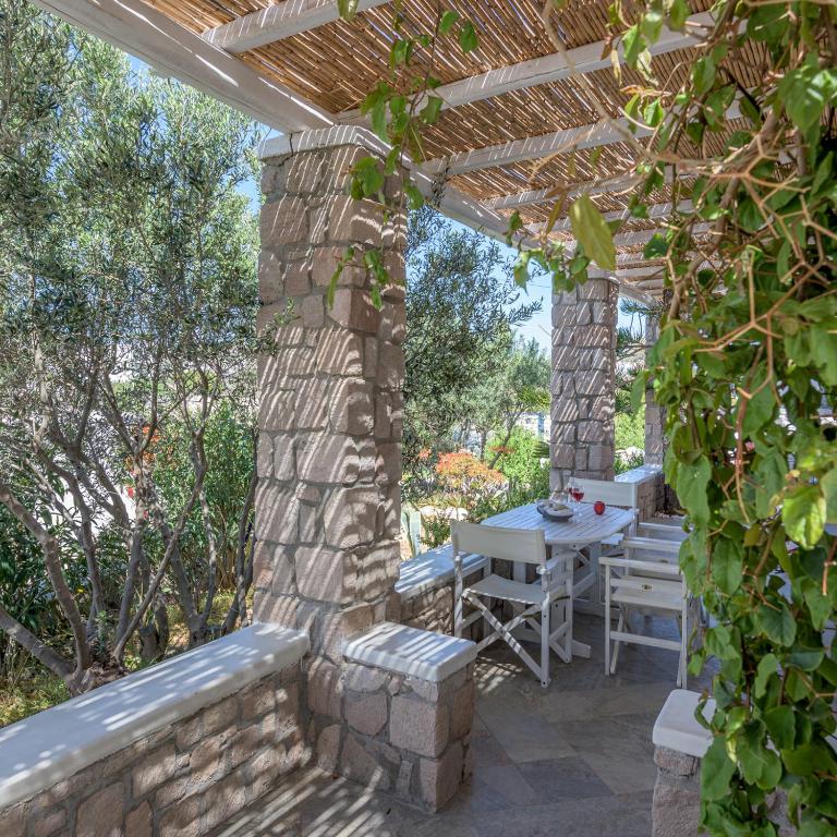 a patio with a table and a wooden pergola at Happy Babi in Adamantas