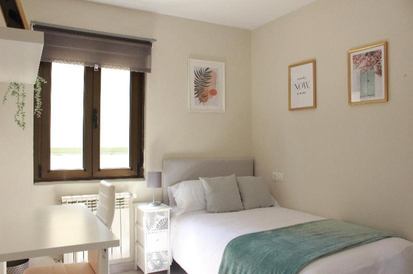 een kleine slaapkamer met een bed en een raam bij Habitación centro Oviedo cerca de estación de buses y trenes in Oviedo