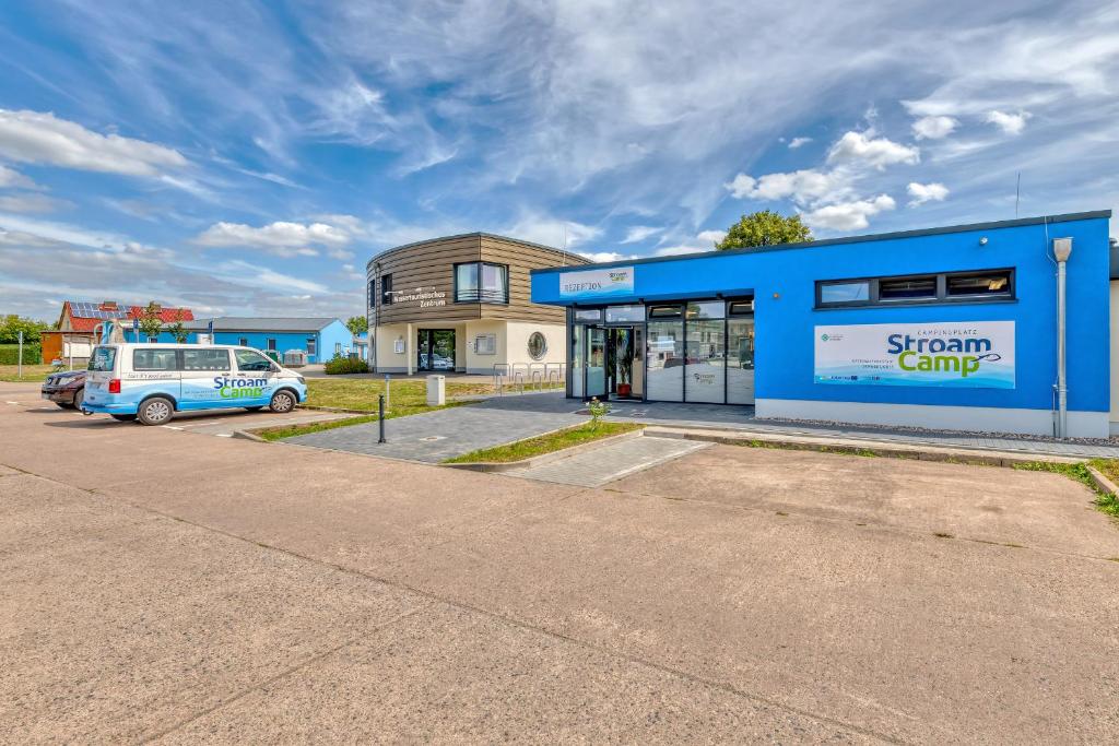 un edificio con una furgoneta estacionada en un estacionamiento en StroamCamp Schwedt - a84452 en Schwedt