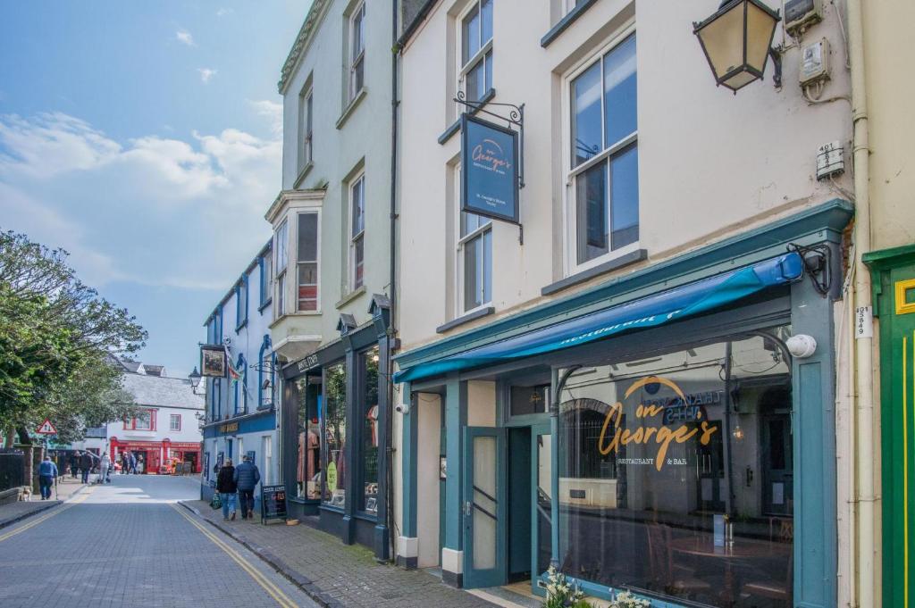 a street with shops on the side of a building at Tipyn O Haul - 1 Bedroom Apartment - Tenby in Tenby