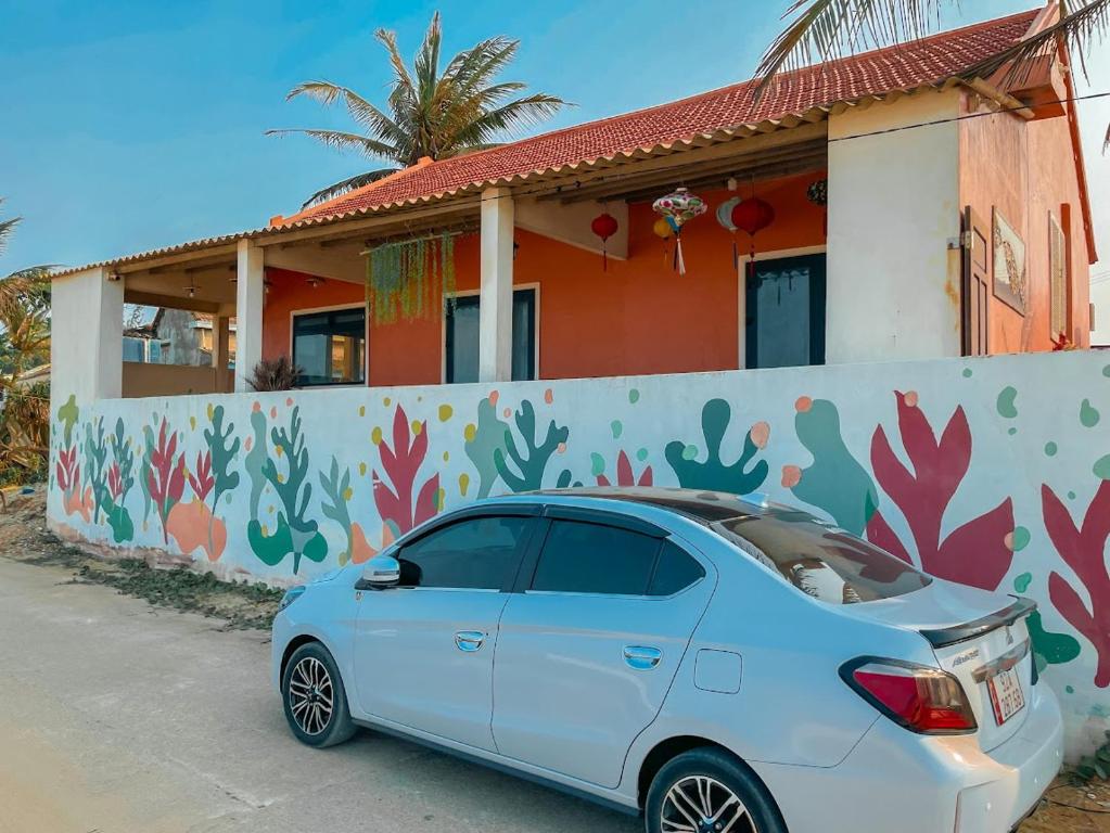 a white car parked in front of a house at orange house in Tam Kỳ