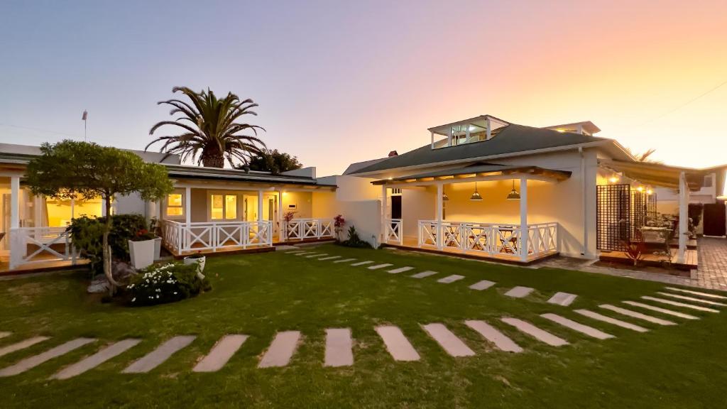 une maison avec une pelouse devant elle dans l'établissement Brigadoon Boutique Guesthouse, à Swakopmund