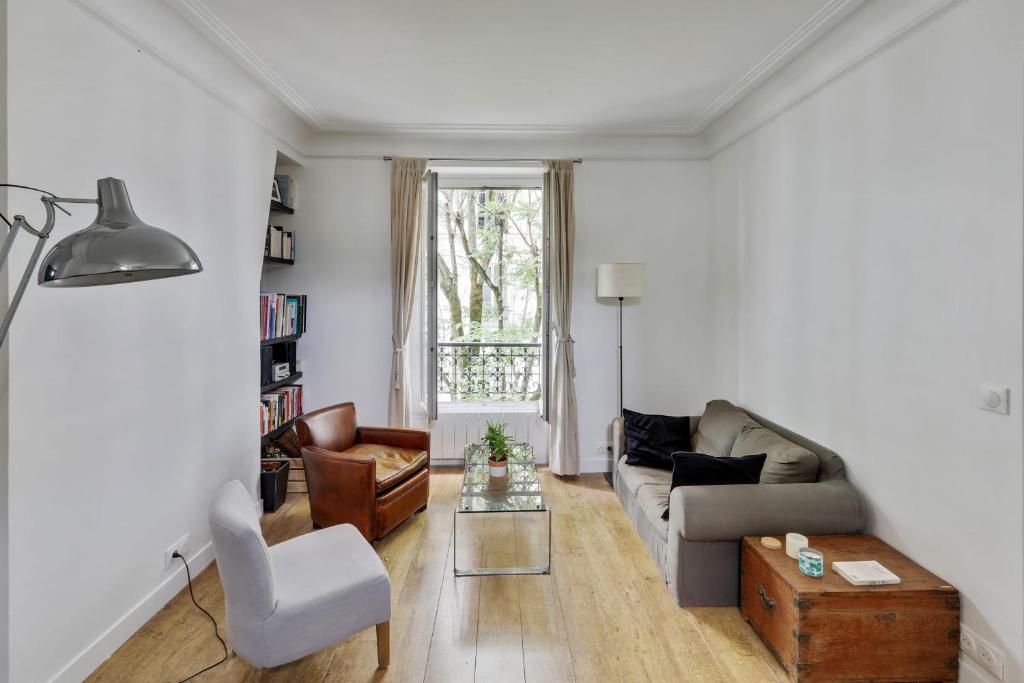 ein Wohnzimmer mit einem Sofa und einem Tisch in der Unterkunft Nice and comfortable flat in Levallois-Perret - Welkeys in Levallois-Perret