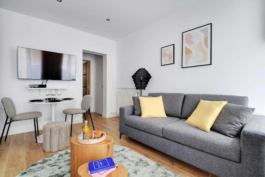 un salon avec un canapé et une table dans l'établissement Welcoming apartment - 1BR-4P - Sacré-Cœur, à Paris