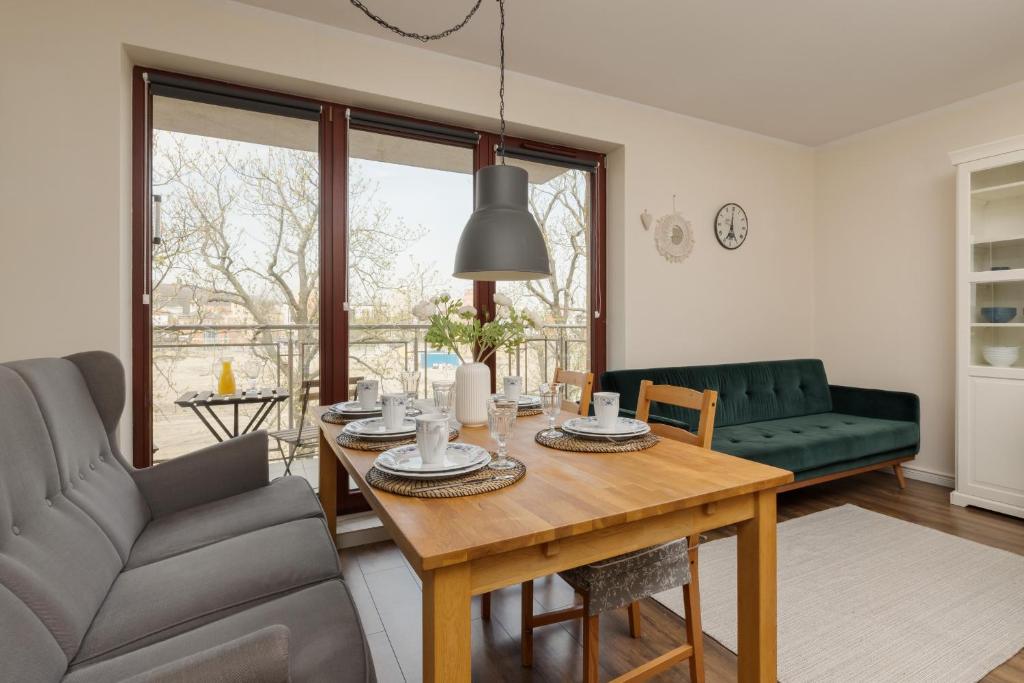 a living room with a table and a couch at City Center Apartment with Balcony by Renters in Gdańsk