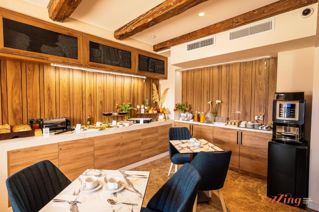 a kitchen with wooden cabinets and a table and chairs at El Doris Boutique Living in Marsaskala