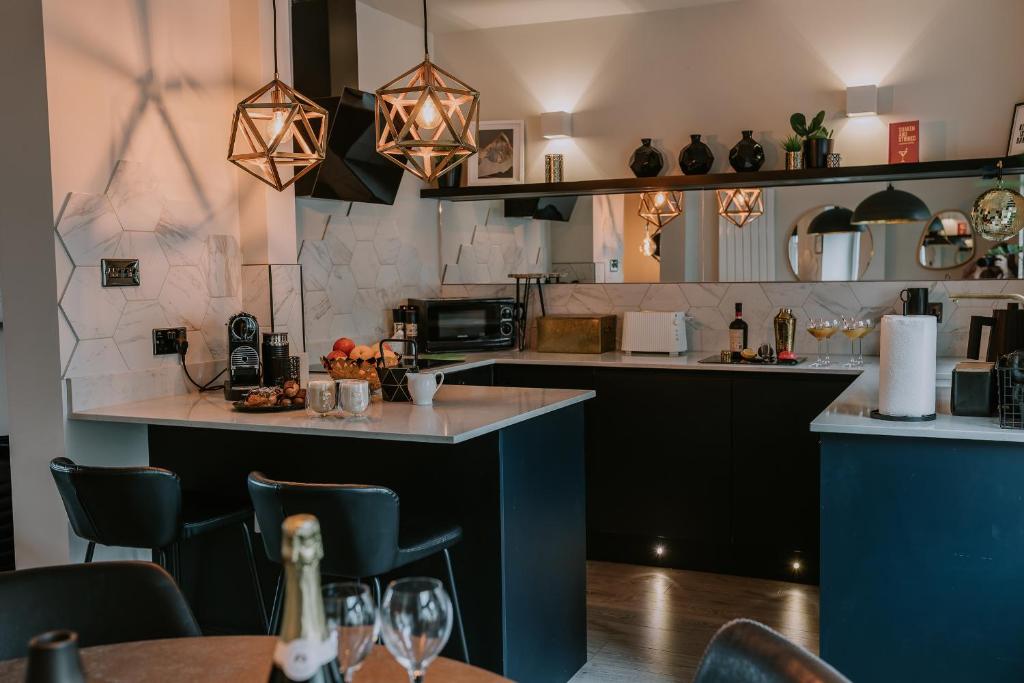 uma cozinha com um bar com cadeiras e uma mesa em 37 Jubilee Street em Llandudno
