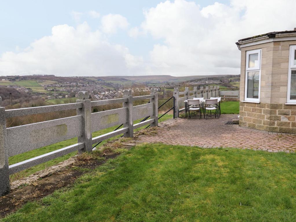 a house with a table and chairs in the grass at Bronte View Hideaway in Keighley