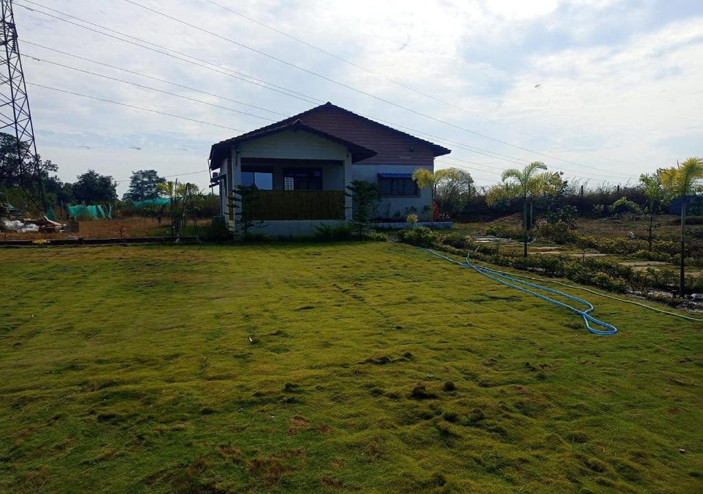 una casa con un patio de césped con una casa en The Palash Vann Resort Madhya Pradesh, en Silāri