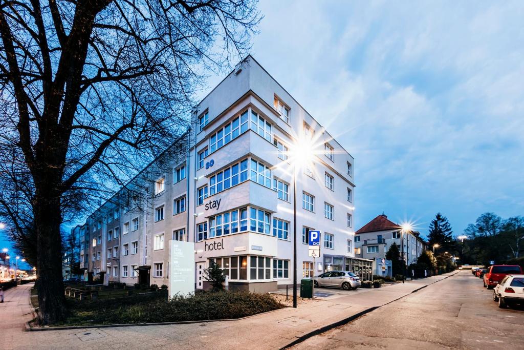 un edificio blanco con una luz de la calle delante de él en So Stay Hotel en Gdansk