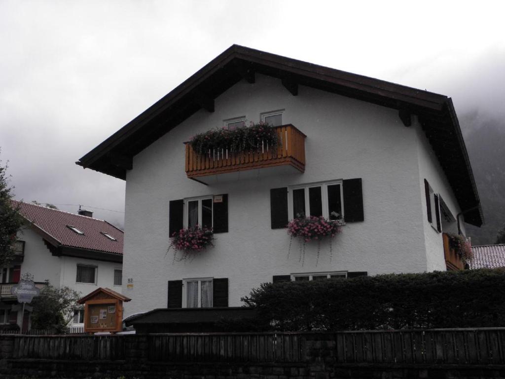 ein weißes Haus mit einem Balkon und Blumen darauf in der Unterkunft Ferienhaus Adelia in Mittenwald