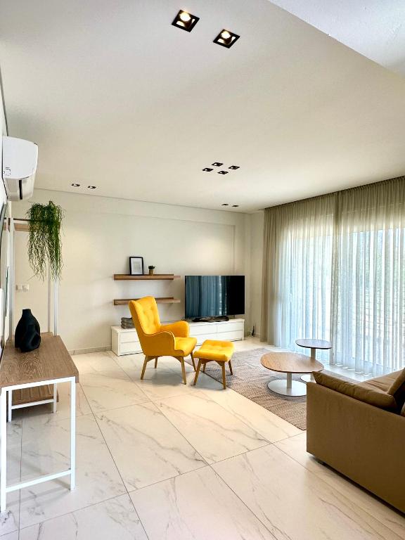 a living room with a couch and a tv at Aerin Residence in Limenaria