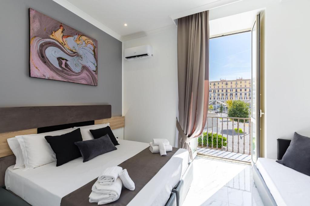 a bedroom with a bed and a large window at Hotel Sant'Angelo Palace in Naples